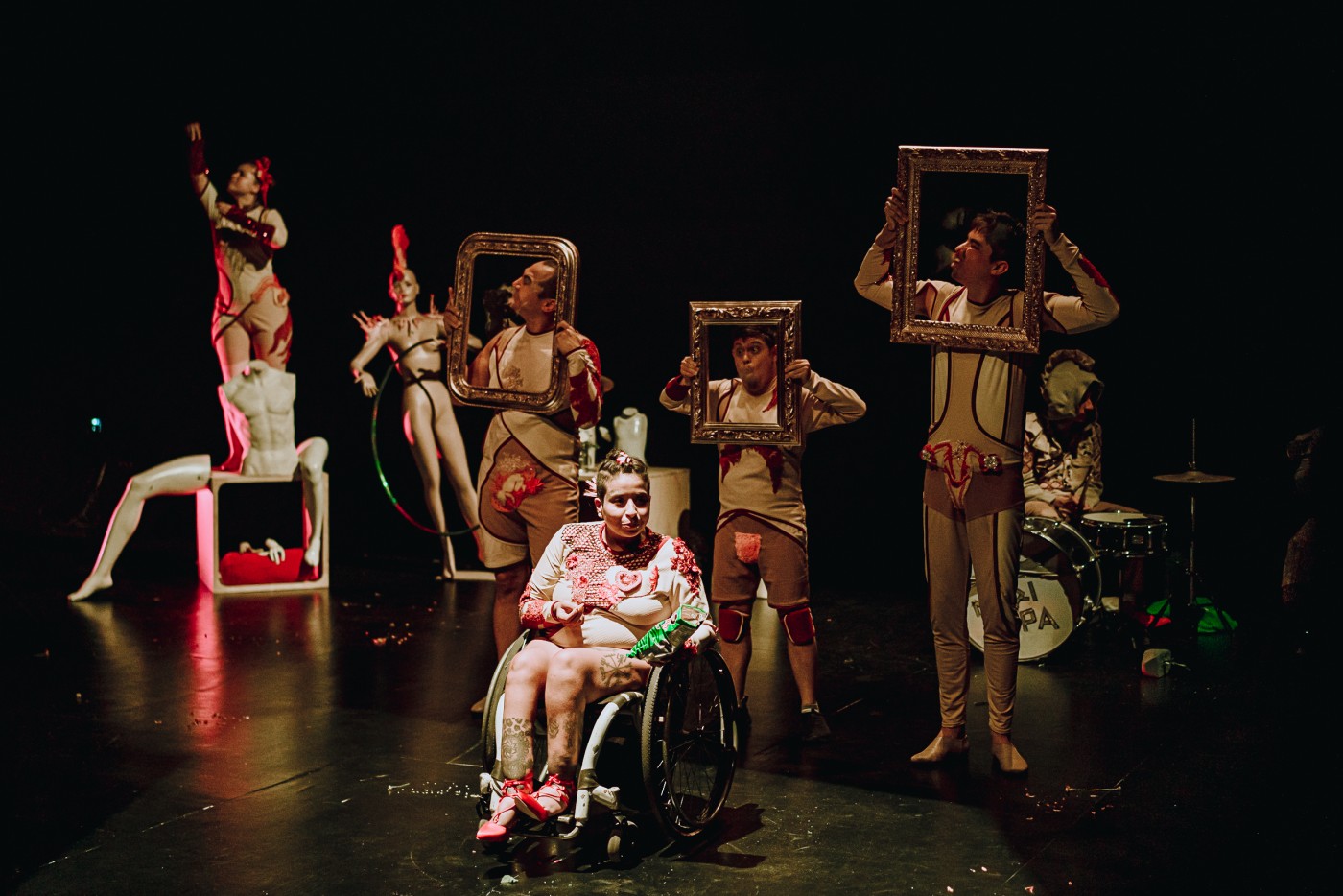 A group of performers on stage holding frames