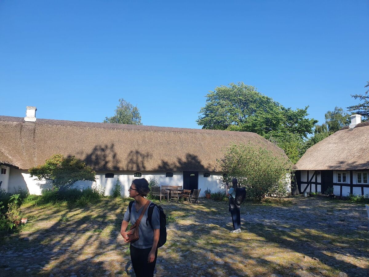 IETM Aarhus two visitors explore traditional housing in the sunshine in rural Denmark during IETM Aurhus