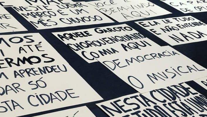 Handpainted signs, written in Portuguese, on the floor of a rehearsal room.