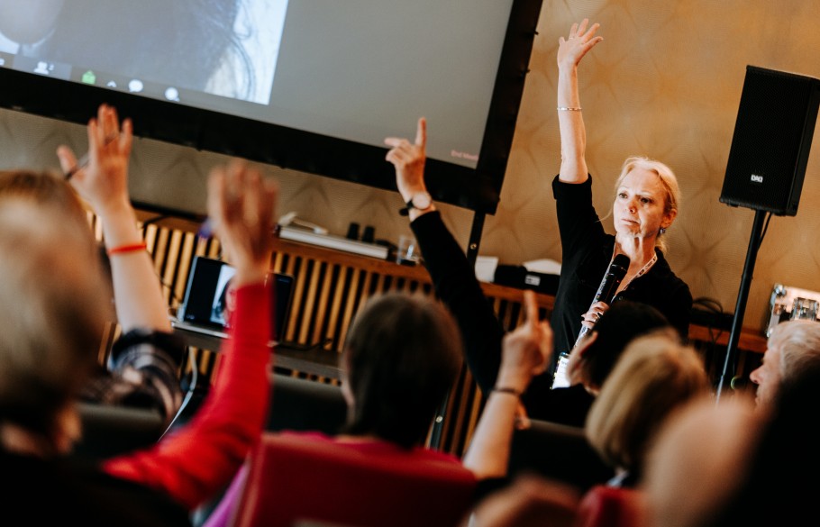 Participants of IETM Hull 2019 raising their hand in front of the speaker