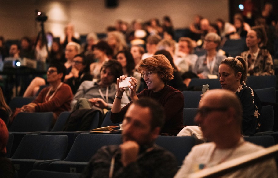 Picture of a participant of IETM Rijeka 2019 taking a picture of the keynote speech with their phone