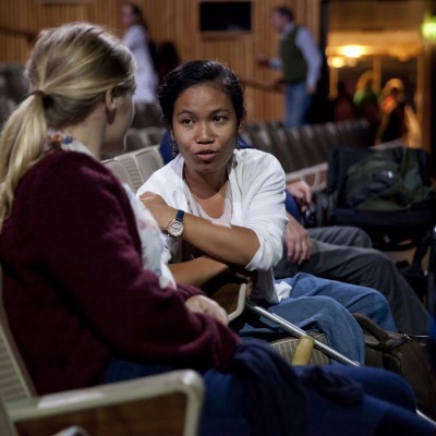 Two woman sat in an empty theatre, speaking actively